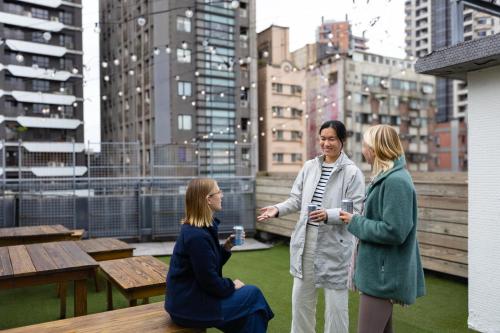 a man talking to two women on a rooftop at MEANDER Taipei in Taipei