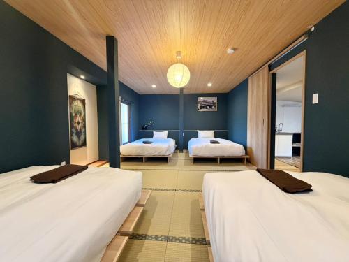 two beds in a room with blue walls at Hotel Kototoi Juku HAKU in Tokyo
