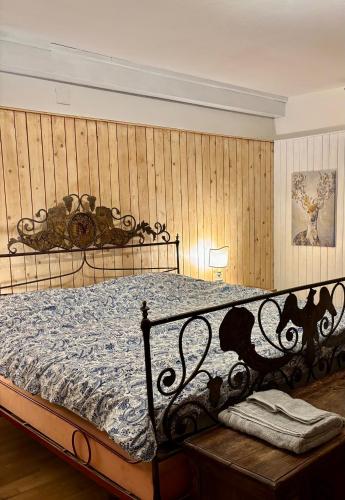 a bedroom with a bed with a wrought iron frame at Ca' Scalinatella in Cortina dʼAmpezzo