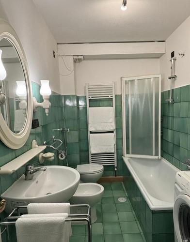 a green and white bathroom with a sink and a toilet at Ca' Scalinatella in Cortina dʼAmpezzo