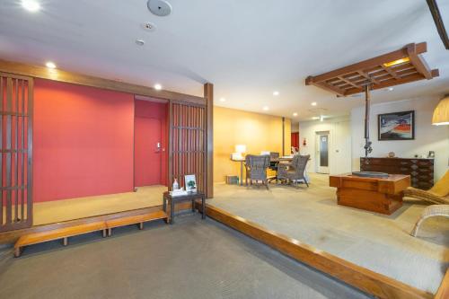 a living room with a red wall and a dining room at Address Nozawa in Nozawa Onsen
