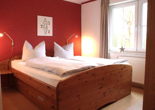 a bed with a wooden frame in a room with a window at Gerdemann in Timmendorf