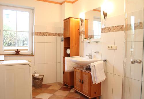 a bathroom with a sink and a mirror and a shower at Gerdemann in Timmendorf
