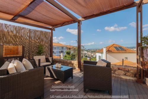 a patio with chairs and a table on a deck at Confluentia H&A - Luxury XIII Century Loft House in Coimbra