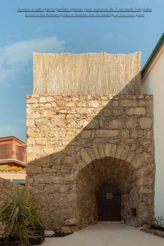 a building with a stone wall with a door at Confluentia H&A - Luxury XIII Century Loft House in Coimbra