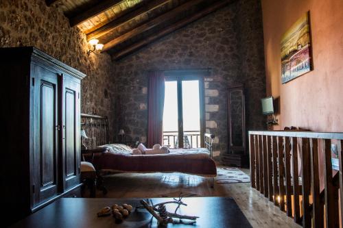 a bedroom with a bed and a large window at Theasis suites-Ορεινή Φιλοξενία in Kato Trikala Korinthias