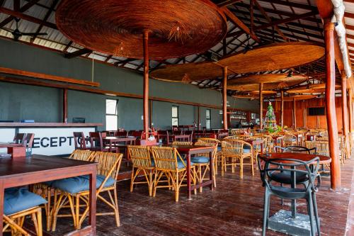 a restaurant with wooden tables and chairs in a room at Onederz Koh Rong Sanloem in Koh Rong Sanloem