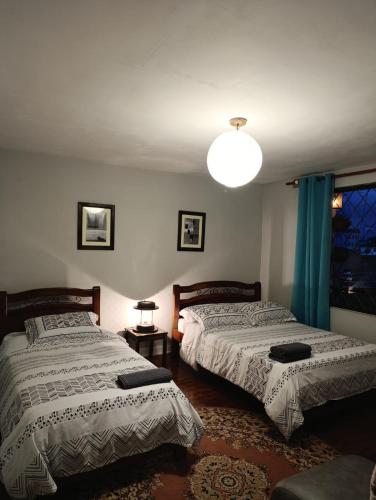 a bedroom with two beds and a light at El Caracol in Popayan