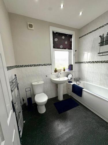 a bathroom with a toilet and a sink and a tub at Stylish Southend 4 Bed Sleeps 7 FastWifi Secure Driveway Parking by The Opulent Property Project UK in Southend-on-Sea