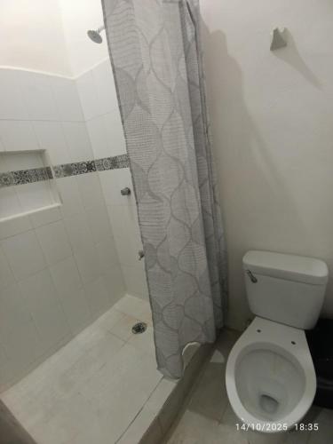 a bathroom with a shower curtain and a toilet at Hotel y Hostal AH MUN in Mérida