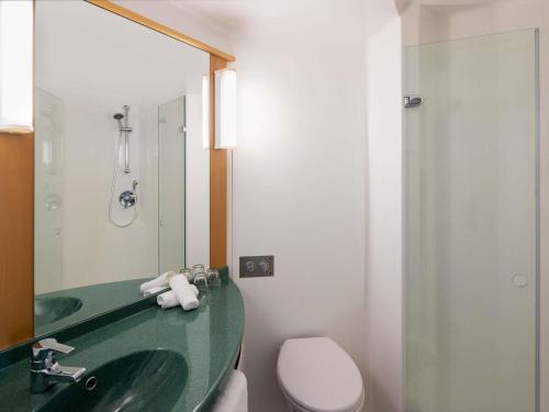 a bathroom with a sink and a toilet and a mirror at ibis Newcastle in Newcastle