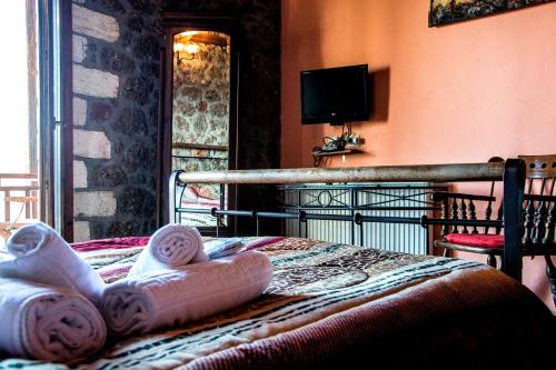 a bedroom with a bed with towels on it at Theasis suites-Ορεινή Φιλοξενία in Kato Trikala Korinthias