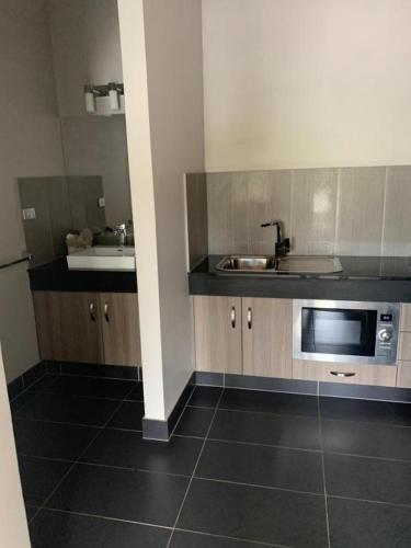 a kitchen with a sink and a microwave at Federation Motel Resort - Corowa in Corowa
