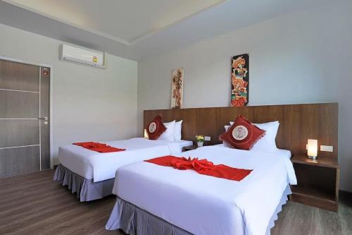 a hotel room with two beds with red pillows at Ohophuket in Phuket