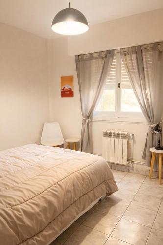 a bedroom with a bed and a window at Dpto SAN MARTIN in Azul