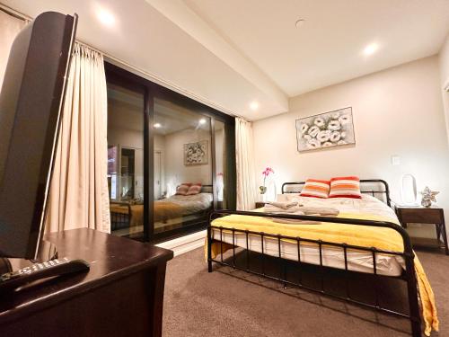 a bedroom with a bed and a television in a room at Connect 204 in Auckland