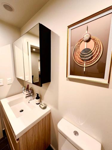 a bathroom with a sink and a mirror at Connect 204 in Auckland