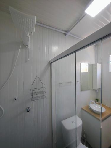 a bathroom with a toilet and a sink and a shower at Loft Navegantes Próximo Aeroporto e BR 101 in Navegantes