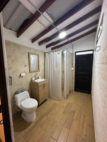 a bathroom with a toilet and a shower and a sink at Finca el origen in Roldanillo