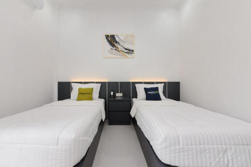 two beds sitting next to each other in a room at Urbanview Hotel AnD Lampung by RedDoorz in Lampung