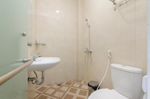 a bathroom with a toilet and a sink at Urbanview Hotel AnD Lampung by RedDoorz in Lampung