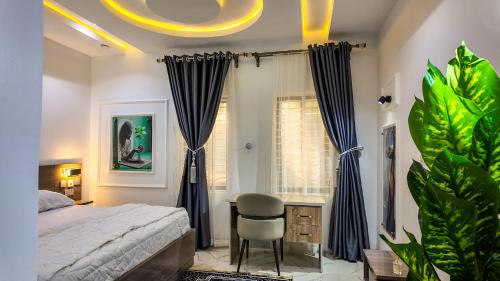 a bedroom with a bed and a chair and a window at Jayhaven Crystal Serviced Apartment in Uyo