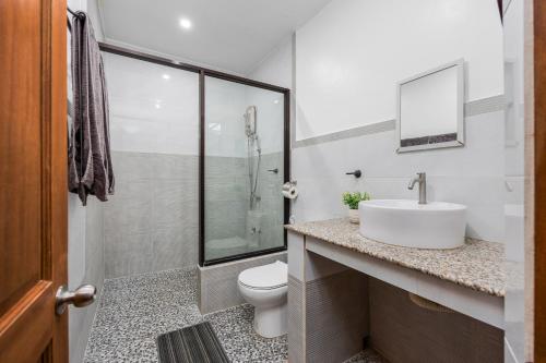 a white bathroom with a sink and a toilet at Badi's Place in Moalboal