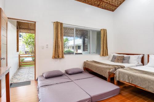 a bedroom with two beds and a window at Badi's Place in Moalboal
