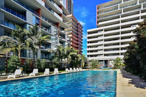 a swimming pool in front of a building at Macquarie Cozy Nest 2BR with Pool Near Train Shopping in Sydney