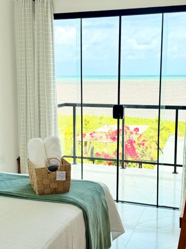 a bedroom with a bed and a view of the ocean at Roraimar Prime Maragogi - Beira Mar in Maragogi
