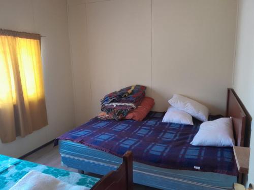 a small bedroom with a bed and a window at Cabaña Bellavista in Manzanar
