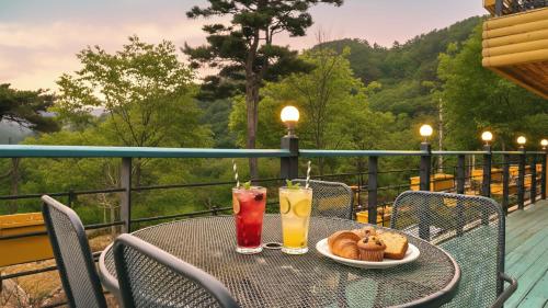 a table with two drinks and food on a balcony at Gangwha Jeongwon Pension in Incheon