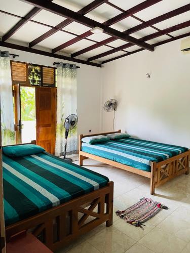 a bedroom with two beds in a room at Golden Palace Yala in Tissamaharama