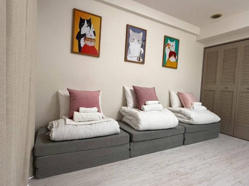 a room with two ottomans with cats on the wall at Ichigaya Stay & Wi-Fi 1 in Tokyo
