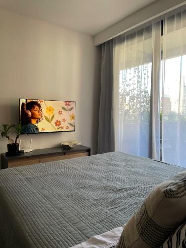 a bedroom with a bed and a flat screen tv at Rosario SJ Loft Studio in Rosario