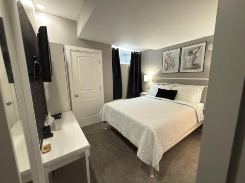 a bedroom with a bed with white sheets and pillows at Stay549 in Winnipeg