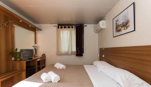 ein Schlafzimmer mit einem Bett mit zwei Handtüchern darauf in der Unterkunft Happy Village in La Giustiniana