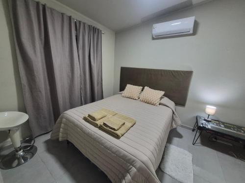 a bedroom with a bed with two towels on it at Pardo Mza in Godoy Cruz