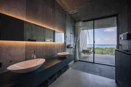 a bathroom with two sinks and a view of the ocean at MERIVAS MOTOBU -Ocean View Sauna Villa- in Motobu