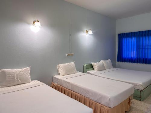 a room with three beds and a window at Chumphon Park Resort in Chumphon