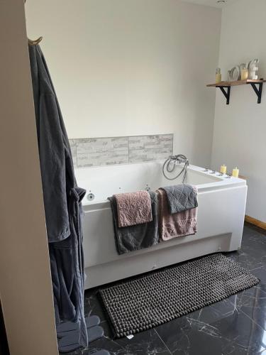 a bathroom with a bath tub with towels on it at Ô Chalet Normand in Colomby