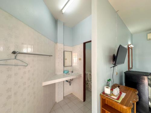 a bathroom with a shower and a toilet and a television at Chumphon Park Resort in Chumphon