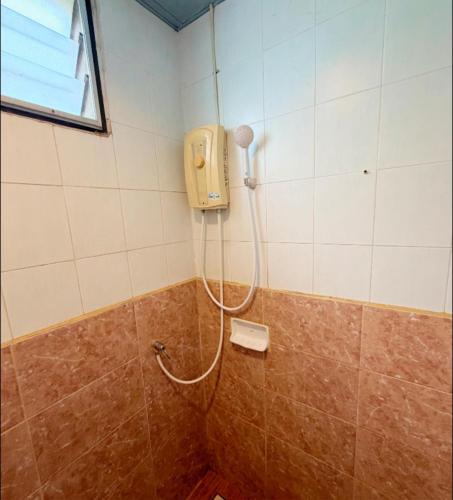 a shower in a bathroom with a phone on the wall at เพิ่มพูนแมนชั่น พิษณุโลก Phoempun Mansion in Sathani Phitsanulok