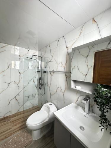 a bathroom with a toilet and a sink and a mirror at Doña Dinde Vacacional in Punta Cana