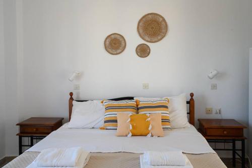 a bedroom with a white bed with two night stands at Porto Analipsi in Maltezana
