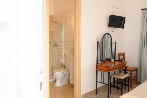 a bathroom with a toilet and a mirror and a desk at Porto Analipsi in Maltezana