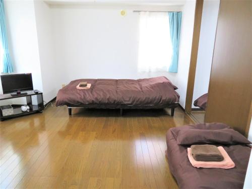 a bedroom with a bed and a tv in it at 札幌市中心部大通公園まで徒歩八分観光移動に便利なロケーションp311B in Sapporo