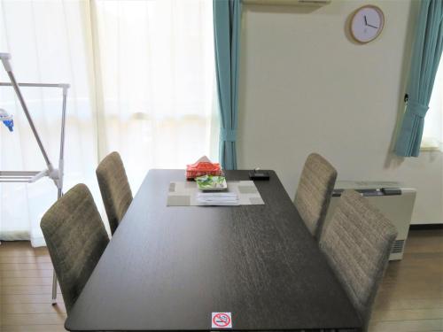 a dining room table with chairs and a clock on the wall at 札幌市中心部大通公園まで徒歩八分観光移動に便利なロケーションp311B in Sapporo