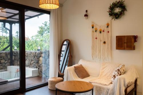 a living room with a couch and a table at 바티하우스 in Ara-ri