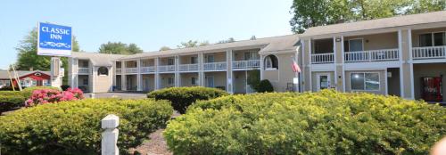 a hotel with bushes in front of a building at Classic Inn in Saco